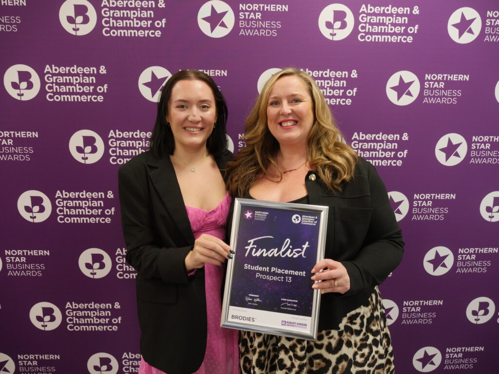 two women holding a framed certificate that states "Finalist Student Placement Prospect 13"